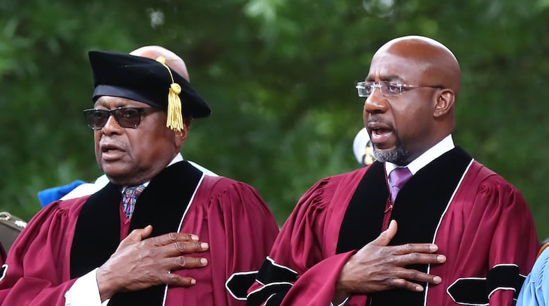 Rep. James E. Clyburn (left) of South Carolina, who received the Honorary Doctor of Laws degree, and Sen. Raphael G. Warnock (right), of Georgia, who received the Honorary Doctor of Humane Letters degree and also deliverd the commencement address, put their hands on their hearts for the presentation of colors and "The Star-Spangled Banner" during the Morehouse College 138th Commencement Ceremony on Sunday, May 15, 2022, in Atlanta. (Curtis Compton/AJC)