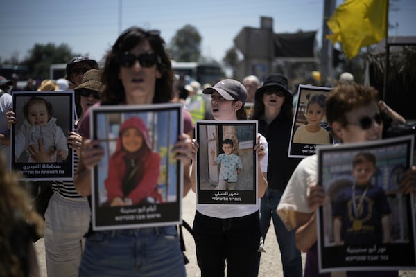 People hold pictures of children killed by Israeli bombardment in the Gaza Strip at a protest demanding the end of the war in an area near the Israeli-Gaza border in Sderot, southern Israel, Friday, May 23, 2025. (AP Photo/Leo Correa)