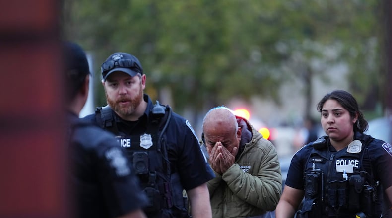 An unidentified man is led into the scene by police after they responded to a shooting at Seattle Center during the Bite of Seattle food festival Sunday, July 26, 2026, in Seattle, Wash. (AP Photo/Lindsey Wasson)
