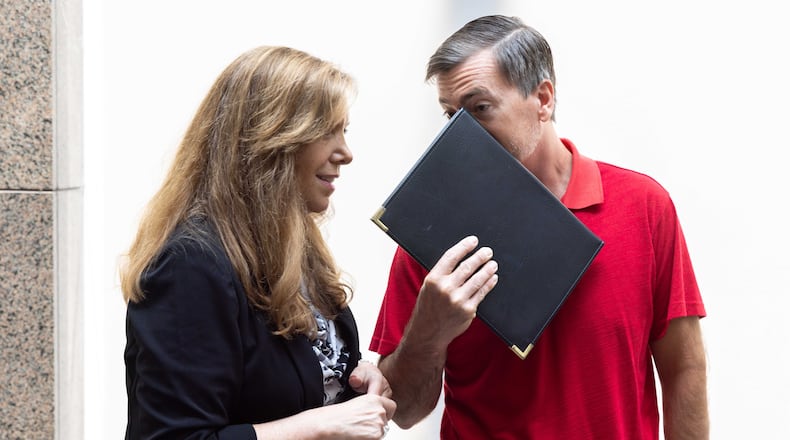 Republican Jason Frazier, who has challenged nearly 10,000 voter registrations under Georgia’s 2021 election voting law, speaks with a supporter after the public comment portion of a Fulton County Board of Commissioners meeting on June 7 in Atlanta. The commissioners rejected Frazier's nomination to the county's election board, and the county's Republican Party has now filed suit in an attempt to force the county to accept his nomination. (Arvin Temkar / arvin.temkar@ajc.com)