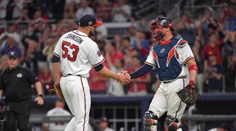 Braves closer Jim Johnson catcher Tyler Flowers shake hands after the Braves home-opening win Friday against the Padres. (HYOSUB SHIN / HSHIN@AJC.COM)