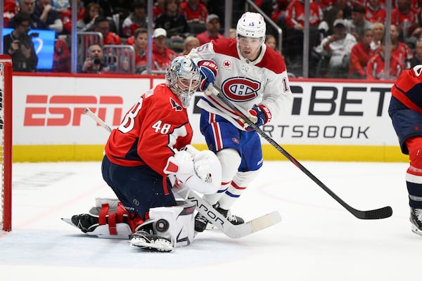 Montreal Canadiens center Alex Newhook (15) and Washington Capitals goaltender Logan Thompson (48) battle for the puck in the second period of Game 1 of a first-round NHL hockey playoff series Monday, April 21, 2025, in Washington. (AP Photo/Nick Wass)