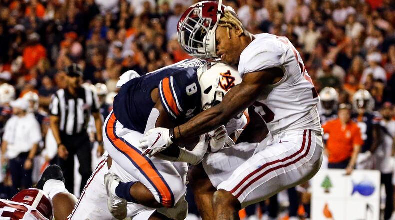 Alabama defensive back Xavier McKinney (15) loses his helmet as Auburn running back Shaun Shivers (8) runs through him for a touchdown during the second half of an NCAA college football game Saturday, Nov. 30, 2019, in Auburn, Ala. (AP Photo/Butch Dill)
