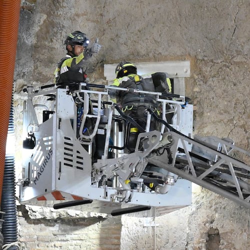 A firefighter gives a thumbs-up as rescuers pull a construction worker from under the debris of a medieval tower that was under renovation near the Roman Forum in Rome, Monday, Nov. 3, 2025, after it partially collapsed earlier in the morning. (Fabrizio Corradetti/LaPresse via AP)