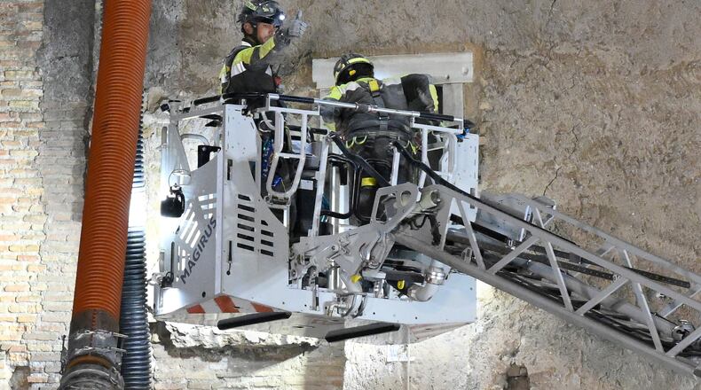 A firefighter gives a thumbs-up as rescuers pull a construction worker from under the debris of a medieval tower that was under renovation near the Roman Forum in Rome, Monday, Nov. 3, 2025, after it partially collapsed earlier in the morning. (Fabrizio Corradetti/LaPresse via AP)