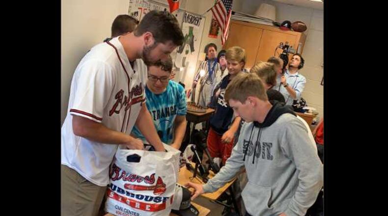 Chad Sobotka, Braves pitcher, hands out shirts and hats to the baseball team at Campbell High School in Smyrna.
