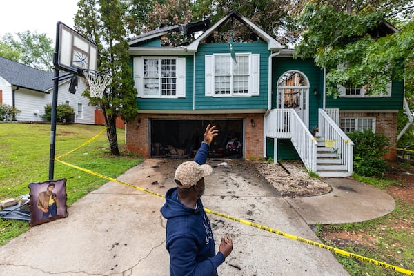 Melvin Wanniplayor points to his home in Gwinnett County after it was struck by lightning May 21 and caught on fire. (Arvin Temkar/AJC)