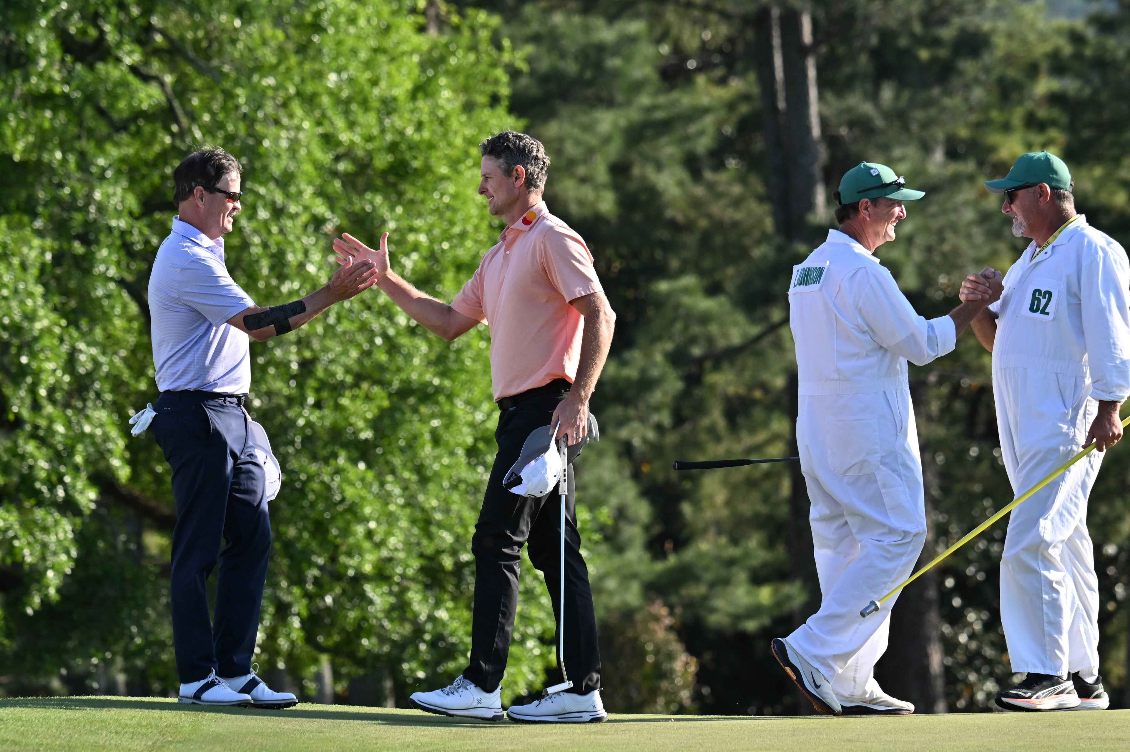 Zach Johnson, shakes hands with Justin Rose as do their caddies, as they finish their final round of the Masters golf tournament, at Augusta National Golf Club, Sunday, April 13, 2025, in Augusta, Ga. (Hyosub Shin / AJC)