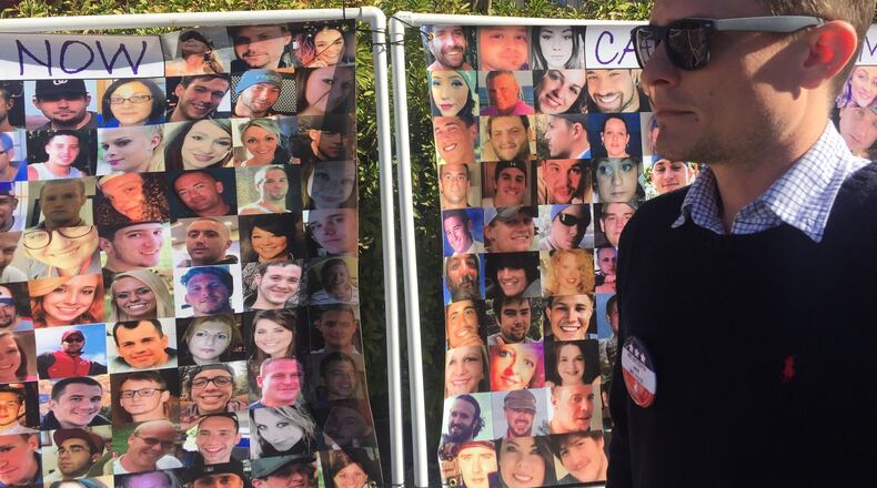 Brett Bramble stands in front of a photo montage of people who died from addiction, including his sister, Brittany. The banner was on display at a recent event across from the Georgia Capitol, to raise awareness for addiction recovery. Bramble sees the state Department of Behavioral Health and Developmental Disabilities as key to stopping the toll of addiction and mental health crises. (PHOTO by Ariel Hart / ahart@ajc.com)