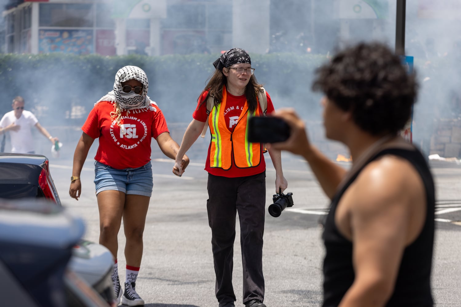 Organizers with the Party for Socialism and Liberation walk through tear gas during a protest on ICE raids and deportation arrests on Chamblee Tucker Road in Atlanta on Saturday, June 14, 2025. (Arvin Temkar / AJC)
