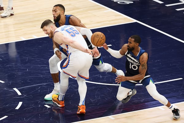 Oklahoma City Thunder center Isaiah Hartenstein (55), Minnesota Timberwolves center Rudy Gobert, and guard Mike Conley (10) reach for a loose ball during the first half of Game 3 of the Western Conference finals of the NBA basketball playoffs, Saturday, May 24, 2025, in Minneapolis. (AP Photo/Matt Krohn)