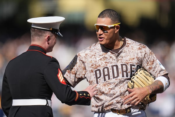 San Diego Padres third baseman Manny Machado greets a Marine before the start of a baseball game against the Atlanta Braves, Sunday, March 30, 2025, in San Diego. (AP Photo/Gregory Bull)