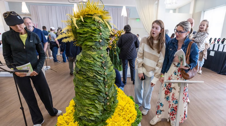 Visitors admire one of the arranged flower exhibits of the division of Floral Design at the Atlanta Botanical Garden on Saturday, February 24, 2024.  (Steve Schaefer/steve.schaefer@ajc.com)