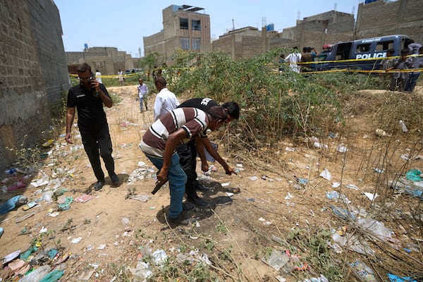 Pakistani investigators examine at a cordoned off site, where Pakistan's air defense system shot down a suspected Indian drone, in Karachi, Pakistan, Thursday, May 8, 2025. (AP Photo/Fareed Khan)