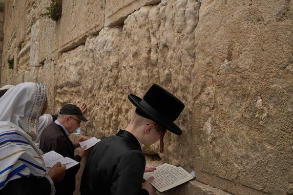 An ultra-Orthodox Jewish young man prays as he participates in a blessing during the holiday of Passover, at the Western Wall, the holiest site where Jews can pray, in the Old City of Jerusalem, Tuesday, April 15, 2025. (AP Photo/Leo Correa)