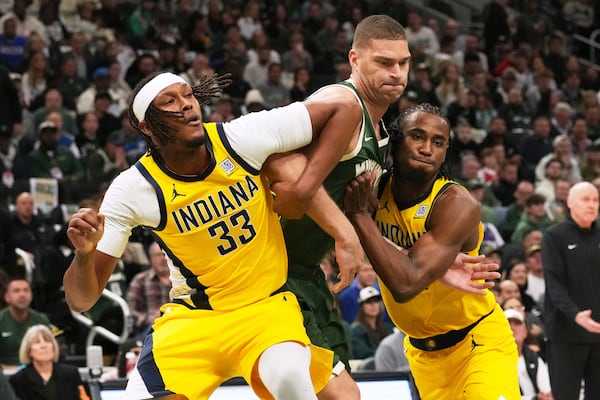 Milwaukee Bucks center Brook Lopez, center, battles for a rebound against Indiana Pacers center Myles Turner, left, and forward Aaron Nesmith during the first half in Game 3 of an NBA basketball first-round playoff series Friday, April 25, 2025, in Milwaukee. (AP Photo/Nam Y. Huh)