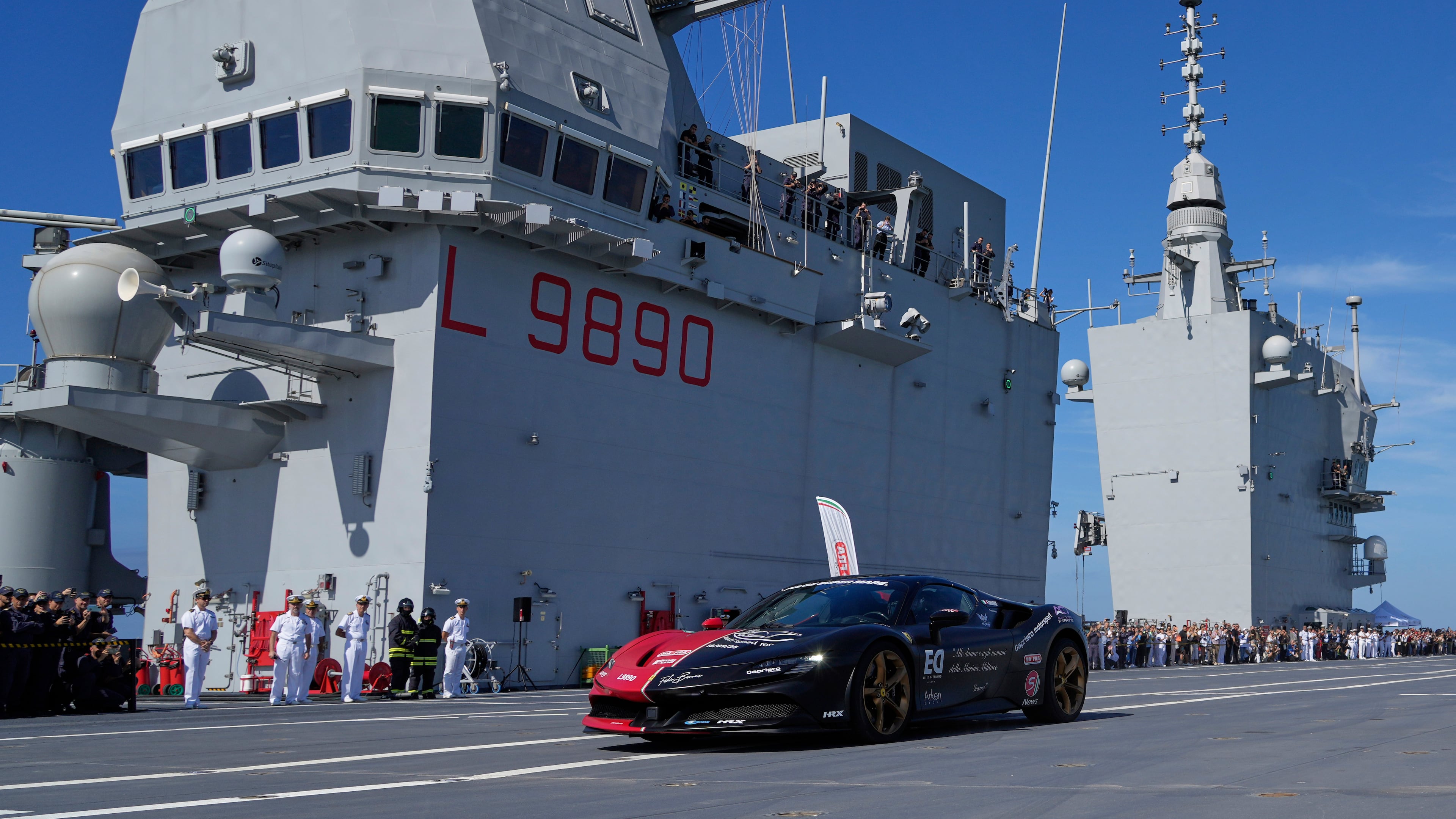 Italian driver Fabio Barone attempts to break his own speed record on a ship, at the wheel of a Ferrari SF 90, on the flight deck of the Italian Navy aircraft carrier Nave Trieste, docked at the port of Civitavecchia, Thursday, Sept. 18, 2025. (AP Photo/Gregorio Borgia)