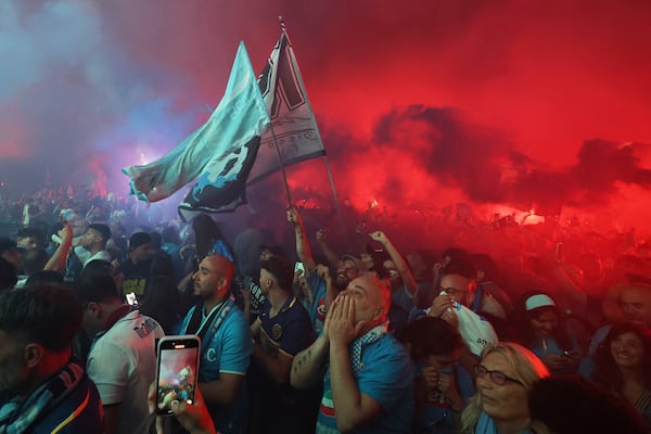 Napoli's fans celebrate as they watch the decisive match for the Italian league soccer title between Napoli and Cagliari on a giant screen set in Piazza del Plebiscito, in Naples, Italy, Friday, May 23, 2025. (AP Photo/Salvatore Laporta)