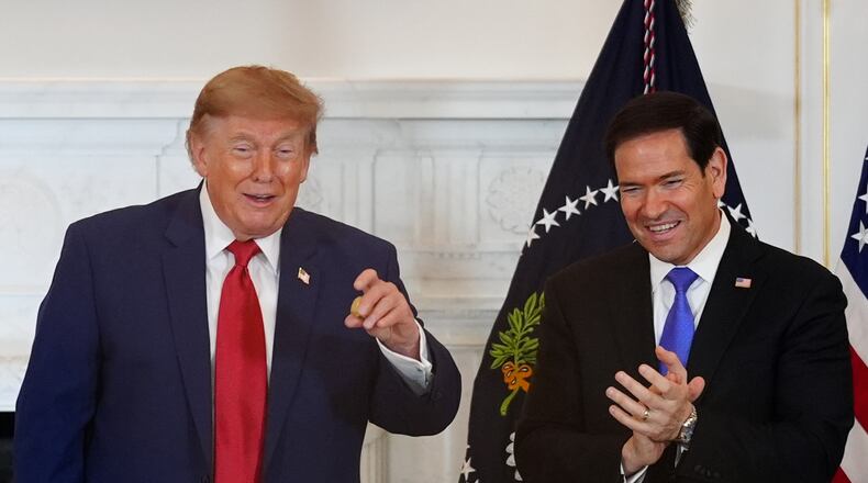 President Donald Trump holds a gold nugget he was presented as Secretary of State Marco Rubio watches during a roundtable on the American mining industry, Friday, Aug. 7, 2026, at the State Department in Washington. (AP Photo/Julia Demaree Nikhinson)