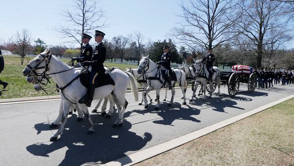 FILE - A U.S. Army Caisson team carries the casket of Lt. Col. Richard Smith during his funeral at Arlington National Cemetery in Arlington, Va., March 28, 2019. (AP Photo/Steve Helber, File)