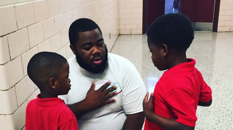 This picture of Markevius Kemp with his two boys last week on the first day at Flat Shoals Elementary School was shared and liked by thousands on social media. (Photo courtesy DeKalb County Public Schools)