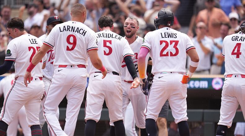 Minnesota Twins' Kody Clemens, back, middle, celebrates with teammates after hitting a walk-off grand slam during the ninth inning of a baseball game against the Kansas City Royals Thursday, July 30, 2026, in Minneapolis. (AP Photo/Abbie Parr)