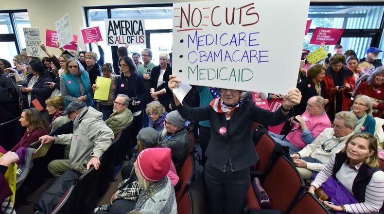 February 10, 2017 Greensboro - Beth Long (foreground) and other protesters hold their signs during Open Office Day event at Greene County Government Office in Greensboro on Friday, February 10, 2017. Hundreds of protesters flocked to a âconstituent service dayâ for U.S. Senators David Perdue and Johnny Isakson and Rep. Jody Hice in this east Georgia town, cheering as one speaker after another railed against the three Republicans and the Trump administration. HYOSUB SHIN / HSHIN@AJC.COM
