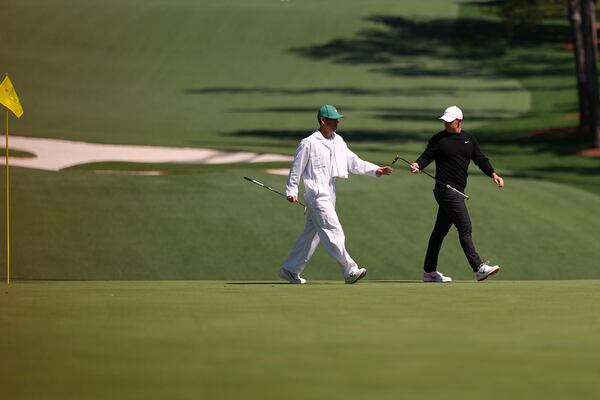Rory McIlroy, of Northern Ireland, hand his club to his caddie, Harry Diamond, left, on the 10th green during a practice round at the Masters golf tournament, Tuesday, April 8, 2025, in Augusta, Ga. (AP Photo/Matt Slocum)