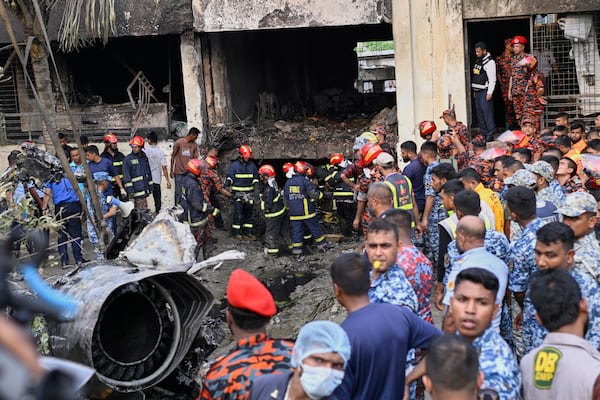 Firemen look for the survivors after a Bangladesh Air Force training aircraft that crashed onto a school campus shortly after takeoff in Dhaka, Bangladesh, Monday, July 21, 2025. (AP Photo/Mahmud Hossain Opu)