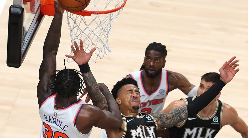 Hawks forward John Collins takes an elbow in the face having to leave the game with a bloody mouth for medical attention on a foul from New York Knicks forward Julius Randle during Game 4 of their first-round NBA playoff matchup Sunday, May 30, 2021, at State Farm Arena in Atlanta. (Curtis Compton / Curtis.Compton@ajc.com)