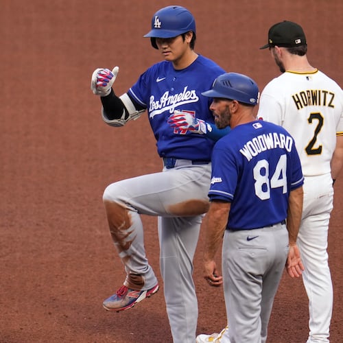 Los Angeles Dodgers' Shohei Ohtani, left, celebrates as he stands on first base after hitting a single off Pittsburgh Pirates pitcher Mitch Keller during the fourth inning of a baseball game in Pittsburgh, Thursday, June 11, 2026. (AP Photo/Gene J. Puskar)