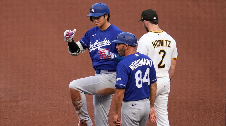 Los Angeles Dodgers' Shohei Ohtani, left, celebrates as he stands on first base after hitting a single off Pittsburgh Pirates pitcher Mitch Keller during the fourth inning of a baseball game in Pittsburgh, Thursday, June 11, 2026. (AP Photo/Gene J. Puskar)