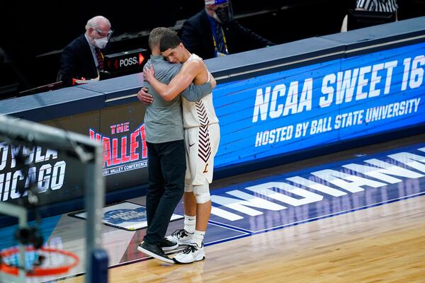 Loyola Chicago head coach Porter Moser, left, hugs guard Lucas Williamson after a Sweet 16 game against Oregon State in the NCAA men's college basketball tournament at Bankers Life Fieldhouse, Saturday, March 27, 2021, in Indianapolis. Oregon State won 65-58. (AP Photo/Darron Cummings)