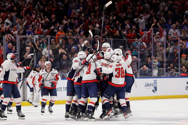 Washington Capitals left wing Alex Ovechkin (8) celebrates with teammates after scoring against New York Islanders during the second period of an NHL hockey game in Elmont, N.Y., Sunday, April 6, 2025. (AP Photo/Adam Hunger)