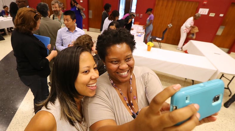 Patreece Hutcherson, right, a candidate for the Atlanta Board of Education, snaps a selfie with a supporter  during a meet and greet before an election forum in August. Hutcherson later filed a federal lawsuit against Atlanta Public Schools over a rule that would bar her from keeping her job at another metro school district should she win the election.