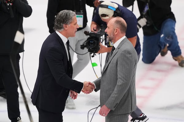 Colorado Avalanche head coach Jared Bednar, left, and Dallas Stars head coach Pete DeBoer, right, greet each other on the ice after their team's Game 7 of a first-round NHL hockey playoff series Saturday, May 3, 2025, in Dallas. (AP Photo/Julio Cortez)