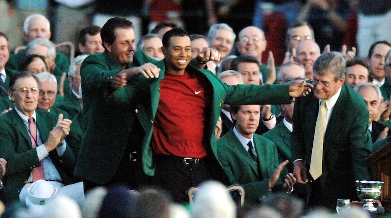 Phil Mickelson puts the green jacket on Tiger Woods as he claims his fourth Masters championship Sunday, April 10, 2005, at Augusta National Golf Club.