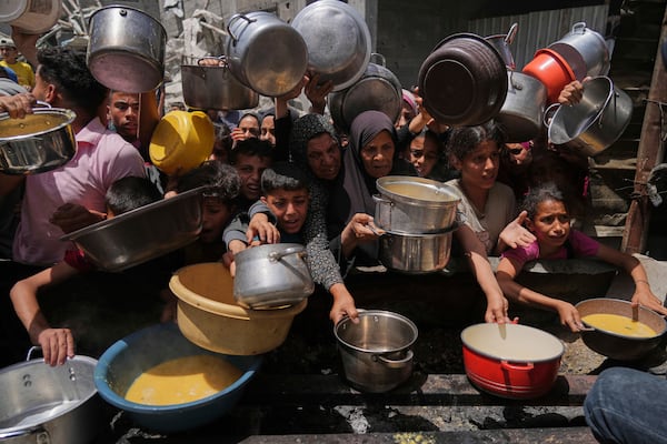 Palestinians struggle to get donated food at a community kitchen in Jabalia, northern Gaza Strip, Monday, May 19, 2025. (AP Photo/Jehad Alshrafi)
