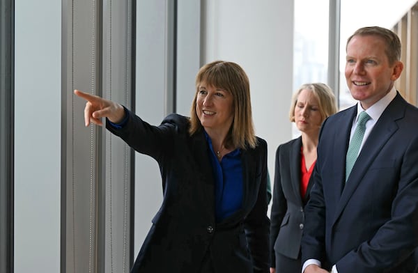 British Chancellor of the Exchequer Rachel Reeves gestures as she talks with Lloyds Banking Group CEO Charlie Nunn as they look from a window before a roundtable discussion with top finance executives at the Lloyds Banking Group's offices, in Leeds, England, Tuesday July 15, 2025. (Oli Scarff/PA via AP)