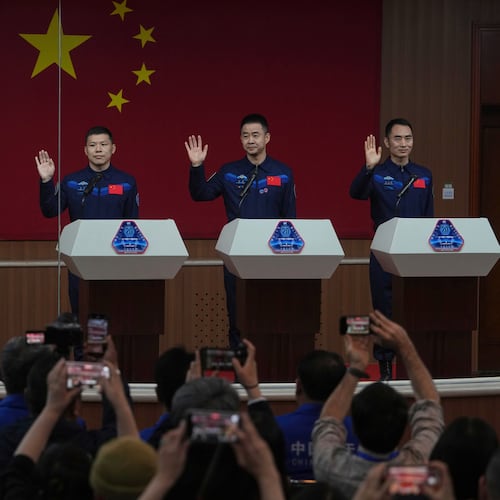 FILE - Journalists film Chinese astronauts for the upcoming Shenzhou 20 mission, from left, Wang Jie, captain Chen Dong and Chen Zhongrui wave at the Jiuquan Satellite Launch Center in northwest China, Wednesday, April 23, 2025. (AP Photo/Andy Wong, file)