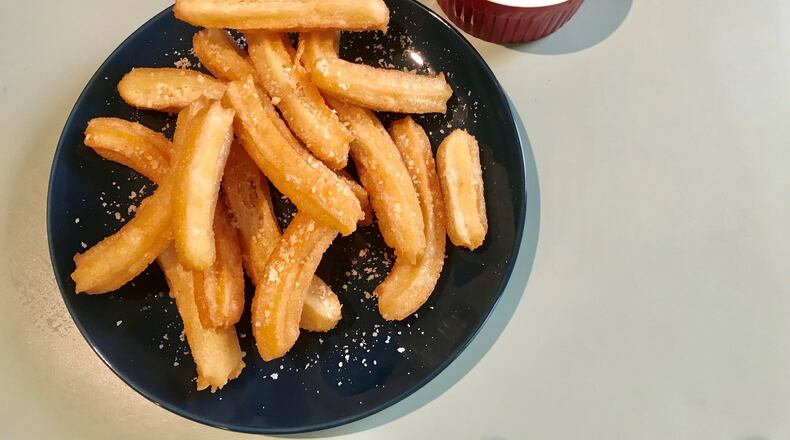 Parmesan Churros are a savory version of a traditionally sweet snack, and marinara sauce is perfect for dipping. LIGAYA FIGUERAS / LFIGUERAS@AJC.COM