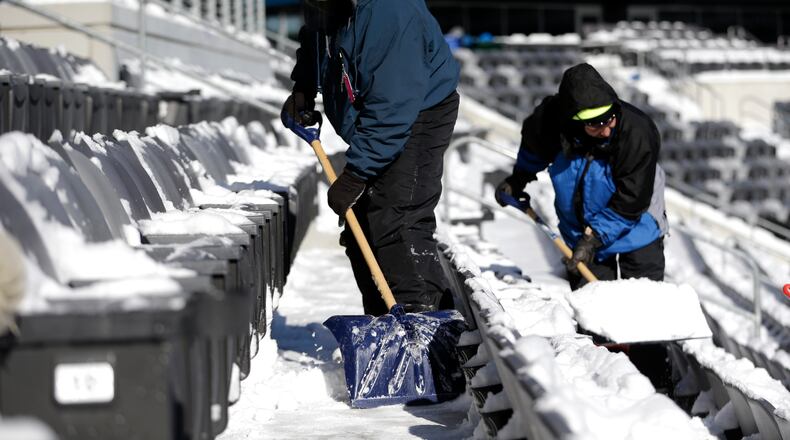 Workers shovel snow off the seates at MetLife Stadium as crews removed snow ahead of Super Bowl XLVIII following a snow storm, Wednesday, Jan. 22, 2014, in East Rutherford, N.J. Super Bowl XLVIII, which will be played between the Denver Broncos and the Seattle Seahawks on Feb. 2, will be the first NFL title game held outdoors in a city where it snows. (AP Photo/Julio Cortez)