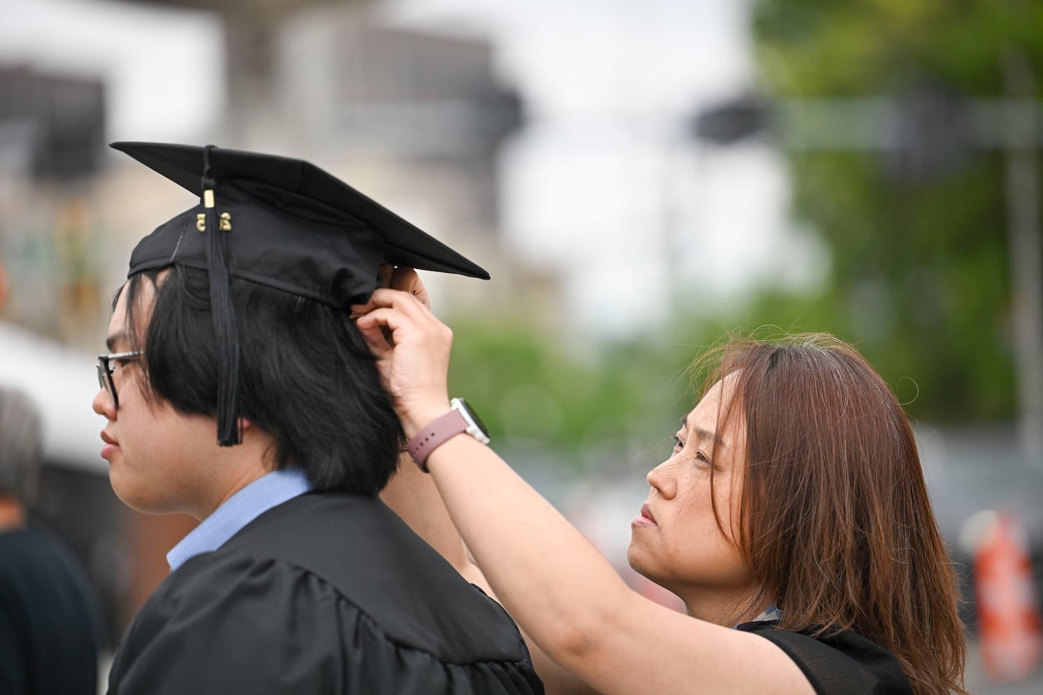Alburt Sun gets help with his graduation cap from his mother Yuan Sun before attending Georgia State University’s Spring commencement ceremony for the College of Arts & Sciences Wednesday, May 7, 2025 in Atlanta. (Daniel Varnado/For the Atlanta Journal-Constitution)