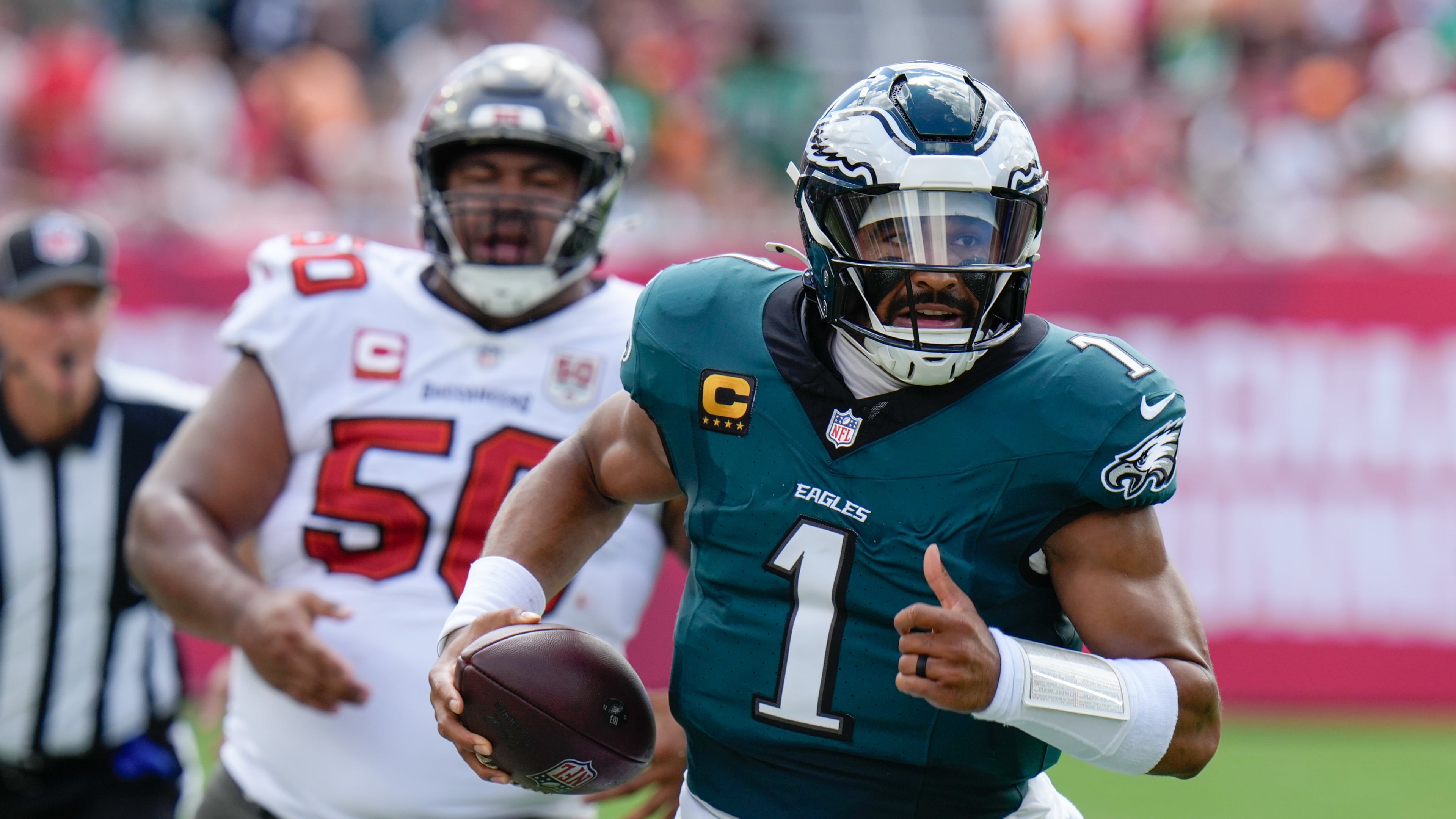 Philadelphia Eagles quarterback Jalen Hurts (1) runs the ball for a first down during the first half of an NFL football game against the Tampa Bay Buccaneers, Sunday, Sept. 28, 2025, in Tampa, Fla. (AP Photo/Chris O'Meara)