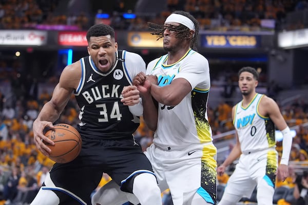 Milwaukee Bucks' Giannis Antetokounmpo (34) battles with Indiana Pacers' Myles Turner, right, during the second half of a first-round NBA basketball playoff game, Saturday, April 19, 2025, in Indianapolis. (AP Photo/Michael Conroy)