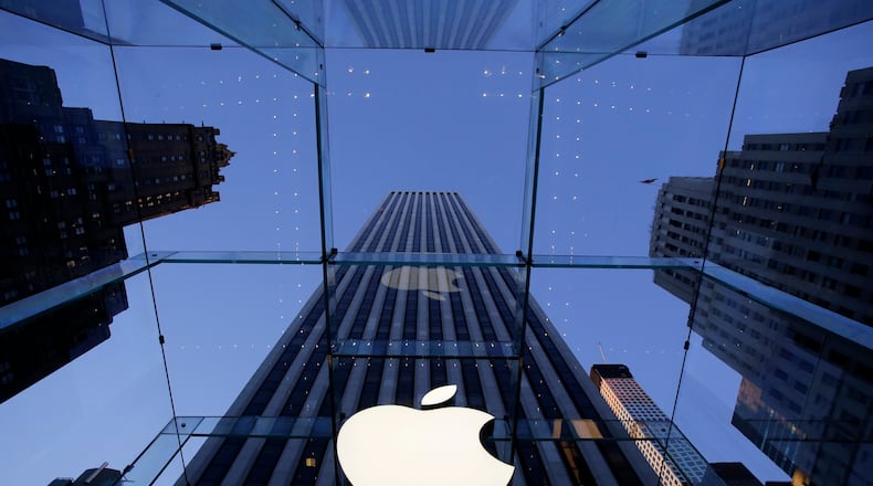 The Apple logo hangs in the glass box entrance to the company's Fifth Avenue store, Thursday, Sept. 5, 2014 in New York. (AP Photo/Mark Lennihan)