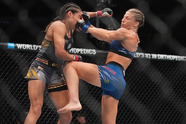Kayla Harrison, right, punches Julianna Peña during the second round of a women's bantamweight bout at the UFC 316 mixed martial arts event Sunday, June 8, 2025 in Newark, N.J. (AP Photo/Frank Franklin II)