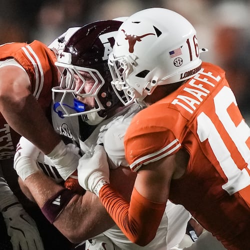 Texas defensive back Warren Roberson (24) and linebacker Liona Lefau (18) bring down Texas A&M tight end Theo Melin Öhrström (17) during the second quarter of an NCAA college football game against Texas A&M in Austin, Texas, Friday, Nov. 28, 2025. (Sara Diggins/Austin American-Statesman via AP)
