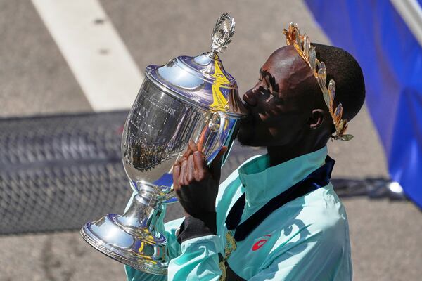 Boston Marathon winner John Korir, of Kenya, kisses the trophy while celebrating after the race, Monday, April 21, 2025, in Boston. (AP Photo/Charles Krupa)