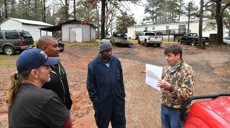 Fletcher Sams (right), executive director at Altamaha Riverkeeper, shows a map of Georgia Power’s ash pond and explains potential problems as (from left) Don Lance, John David Johnson and Huriah Stewart look on. Sams collected water samples at Johnson’s home near Georgia Power’s coal-fired power plant in Juliette. Johnson says he hasn’t drunk the water in Juliette for years. HYOSUB SHIN / HYOSUB.SHIN@AJC.COM